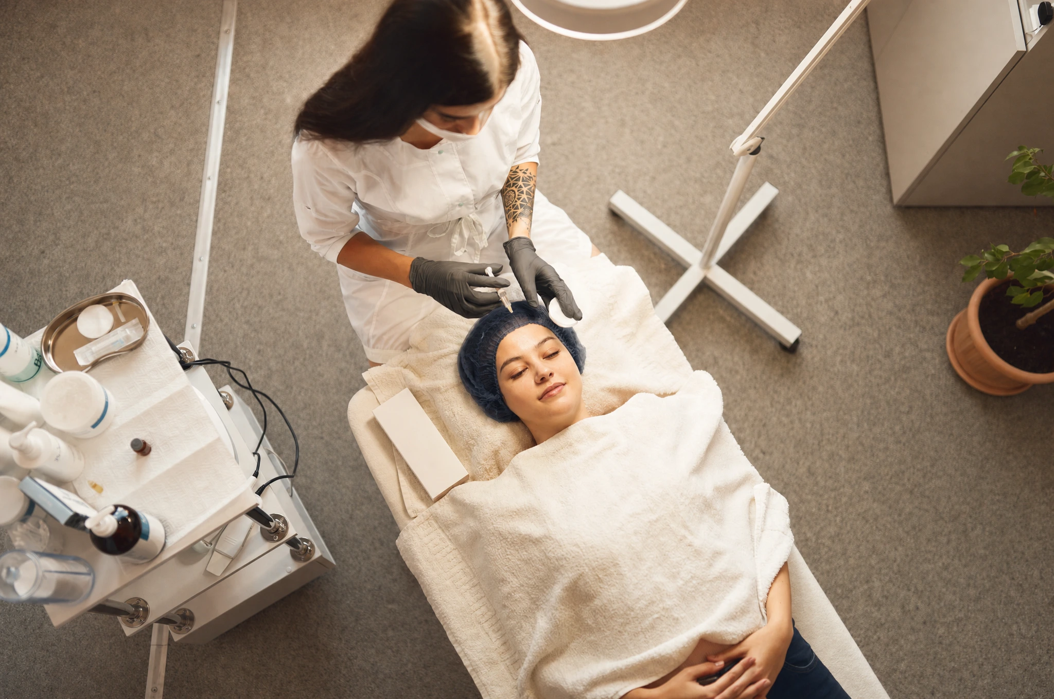 A med-spa practitioner reviewing a digital intake form on a tablet in a clean treatment room.